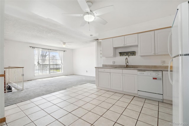 kitchen featuring a ceiling fan, a sink, white cabinets, light carpet, and white appliances