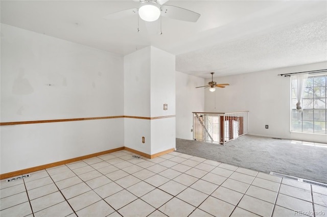 unfurnished room with baseboards, light carpet, a ceiling fan, and visible vents