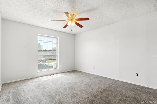 carpeted empty room featuring baseboards, ceiling fan, and a textured ceiling