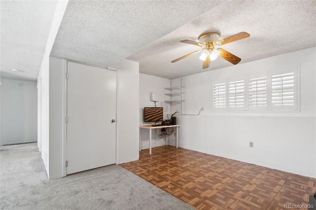 basement featuring a ceiling fan and a textured ceiling