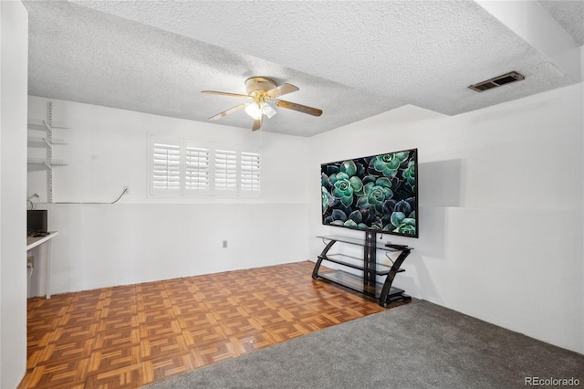 interior space with visible vents, a ceiling fan, and a textured ceiling