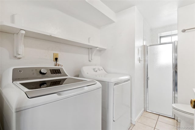 laundry area featuring light tile patterned floors, laundry area, and washer and clothes dryer
