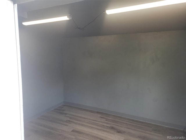 spare room featuring baseboards and wood finished floors