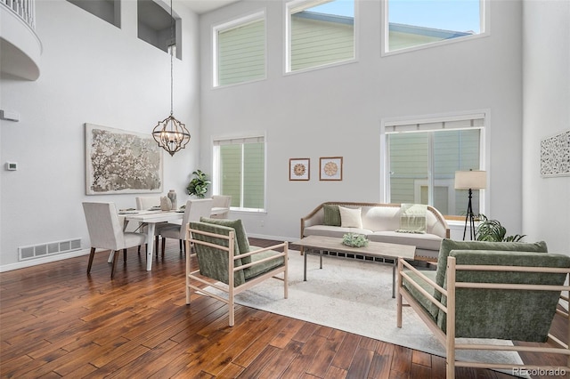 2749 Pemberly Ave, Highlands Ranch, CO 80126 - living room with a towering ceiling, a chandelier, dark wood-style flooring, and baseboards
