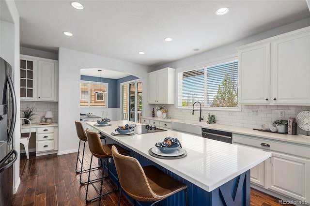 2749 Pemberly Ave, Highlands Ranch, CO 80126 - kitchen with a sink, decorative backsplash, white cabinets, a kitchen island, and appliances with stainless steel finishes
