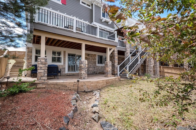 2749 Pemberly Ave, Highlands Ranch, CO 80126 - rear view of property with stairway, fence, stone siding, a patio area, and a deck
