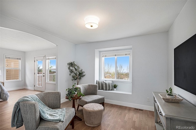 2749 Pemberly Ave, Highlands Ranch, CO 80126 - sitting room featuring arched walkways, baseboards, and light wood-style flooring
