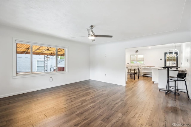 2989 S Corona St, Englewood, CO 80113 - unfurnished living room featuring dark wood-style floors, ceiling fan, and baseboards