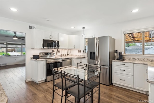 2989 S Corona St, Englewood, CO 80113 - kitchen featuring appliances with stainless steel finishes, a sink, ceiling fan, white cabinetry, and dark wood finished floors