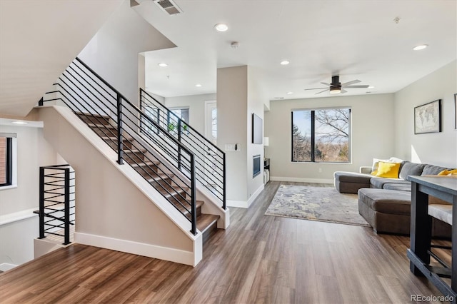 living room featuring recessed lighting, wood finished floors, visible vents, and baseboards