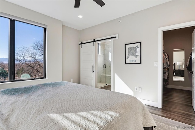 bedroom featuring recessed lighting, a barn door, connected bathroom, wood finished floors, and baseboards