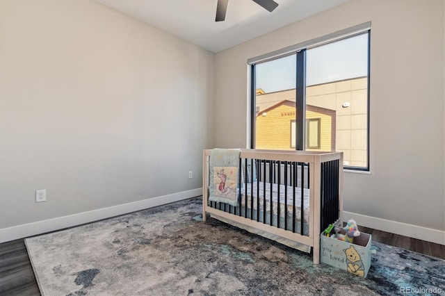 bedroom featuring multiple windows, baseboards, and wood finished floors