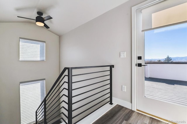 interior space featuring vaulted ceiling, plenty of natural light, wood finished floors, and baseboards