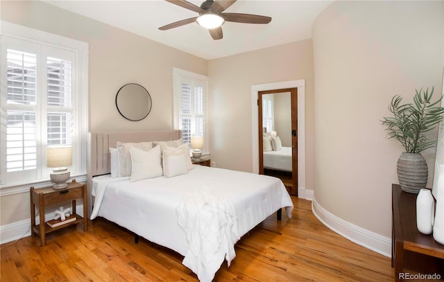 bedroom with baseboards, ceiling fan, and light wood finished floors