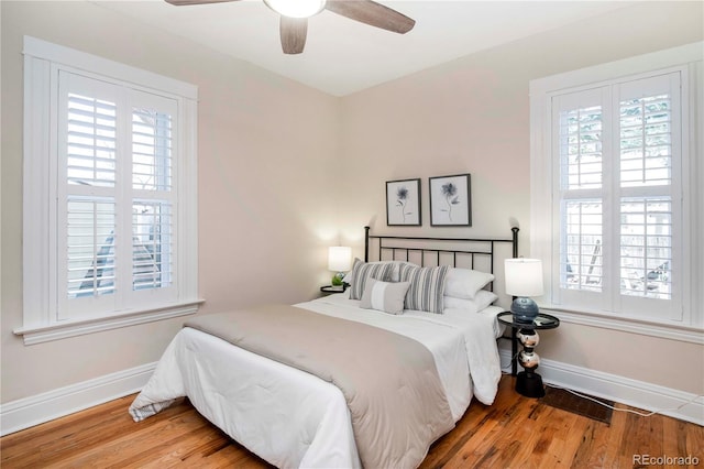 bedroom featuring wood finished floors, a ceiling fan, and baseboards