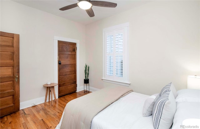 bedroom with ceiling fan, baseboards, and wood finished floors