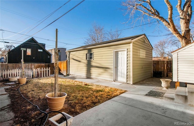 view of outbuilding featuring fence and an outdoor structure