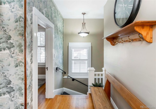 entryway with light wood-style floors, baseboards, and wallpapered walls