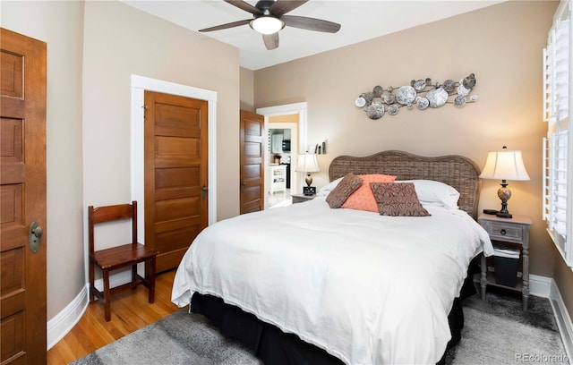 bedroom featuring a ceiling fan, baseboards, and wood finished floors