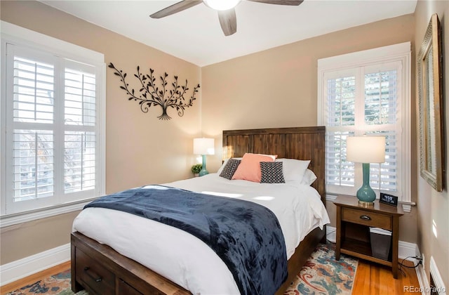 bedroom featuring a ceiling fan, baseboards, and wood finished floors