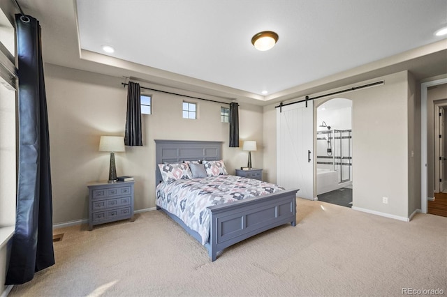 bedroom featuring a barn door, carpet, and baseboards