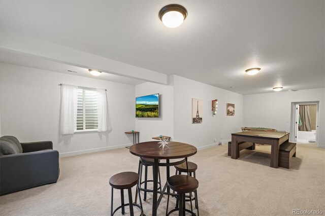 game room with visible vents, baseboards, a textured ceiling, and light colored carpet