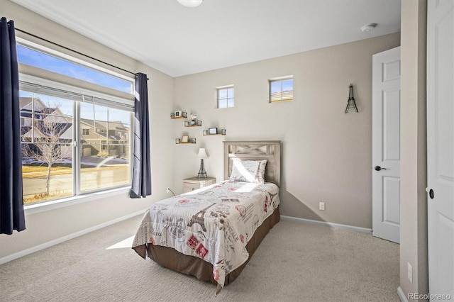 carpeted bedroom with multiple windows and baseboards