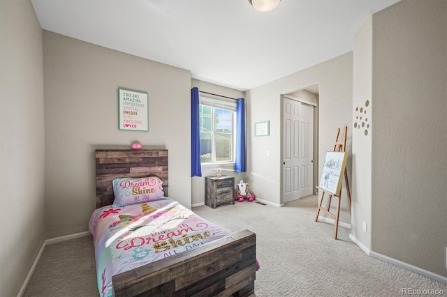 carpeted bedroom with a closet and baseboards