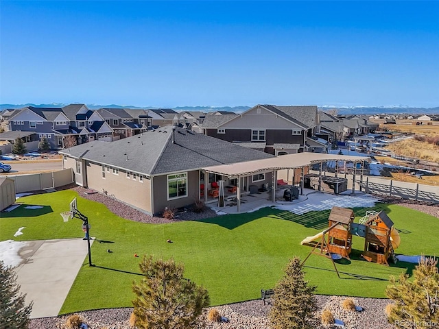 rear view of property with playground community, a residential view, a fenced backyard, and a patio area