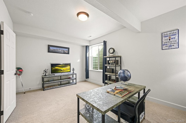 home office with visible vents, beamed ceiling, light colored carpet, and baseboards