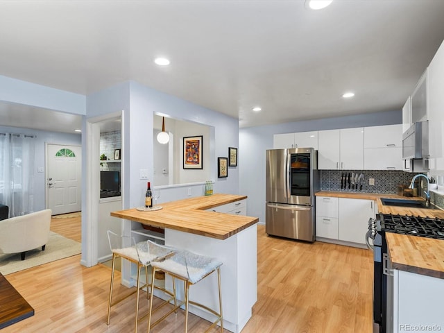10109 W 68th Ave, Arvada, CO 80004 - kitchen featuring butcher block countertops, smart refrigerator, a sink, gas range, and a kitchen bar