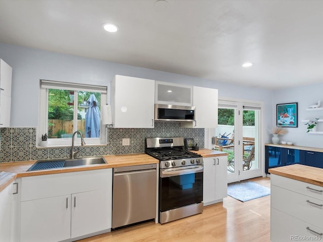 10109 W 68th Ave, Arvada, CO 80004 - kitchen with butcher block counters, stainless steel appliances, a sink, and plenty of natural light