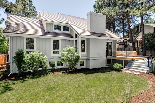 10953 E Crestline Ave, Englewood, CO 80111 - back of house with a chimney, a yard, a wooden deck, and board and batten siding