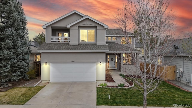 traditional-style house featuring concrete driveway, a shingled roof, fence, a garage, and stucco siding