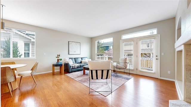 living room with baseboards, a wealth of natural light, and light wood-style flooring