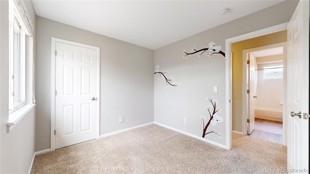 interior space featuring baseboards and light colored carpet