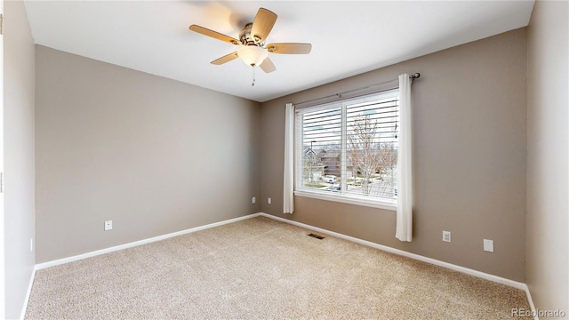spare room with carpet, baseboards, and ceiling fan