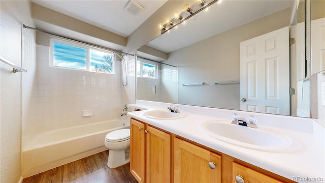 bathroom with bathtub / shower combination, wood finished floors, a sink, and toilet