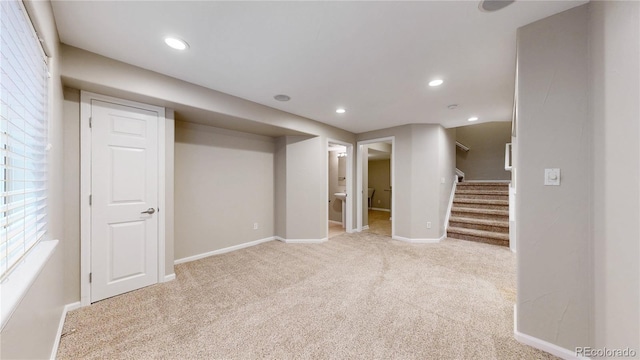 below grade area featuring baseboards, carpet floors, recessed lighting, and stairway