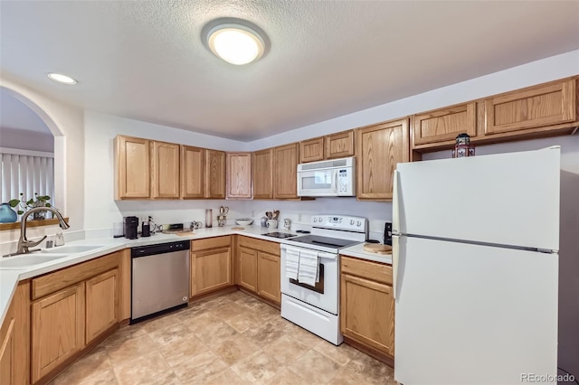 8900 Fox Dr Unit 1, Thornton, CO 80260 - kitchen featuring white appliances, arched walkways, light countertops, recessed lighting, and a textured ceiling