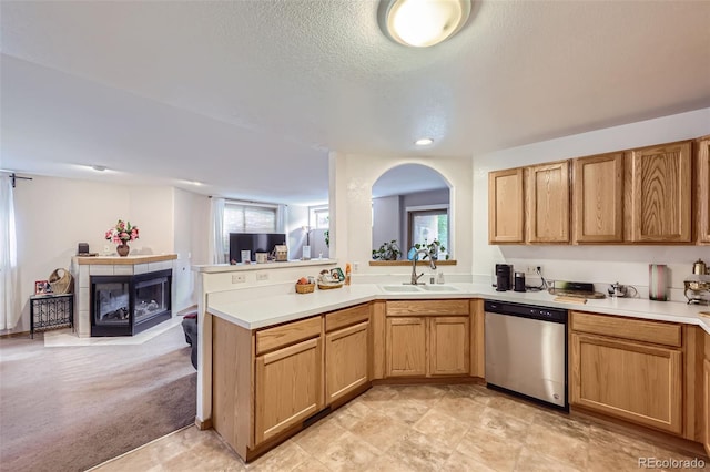 8900 Fox Dr Unit 1, Thornton, CO 80260 - kitchen featuring stainless steel dishwasher, light countertops, plenty of natural light, a glass covered fireplace, and recessed lighting