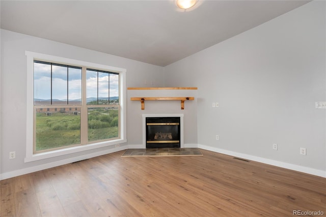 unfurnished living room featuring lofted ceiling and wood-type flooring