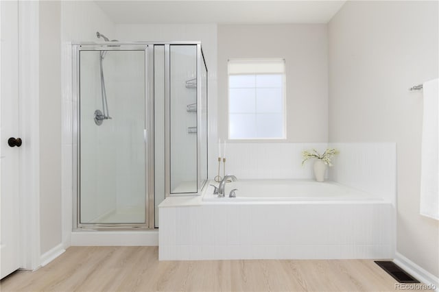 full bath with a stall shower, visible vents, a garden tub, and wood finished floors