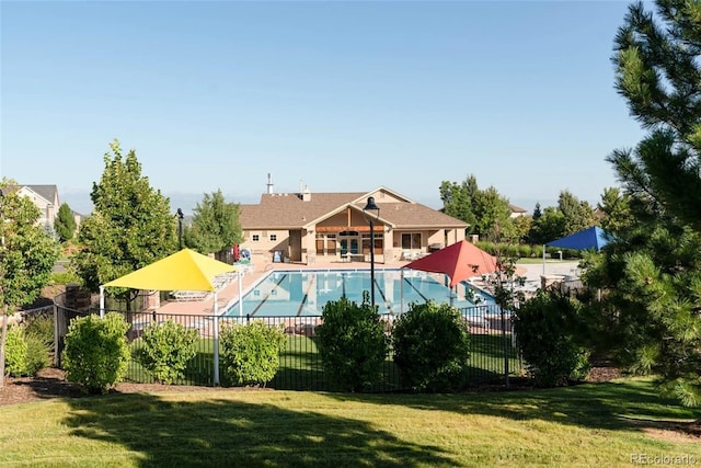 community pool with a yard, a patio area, and fence