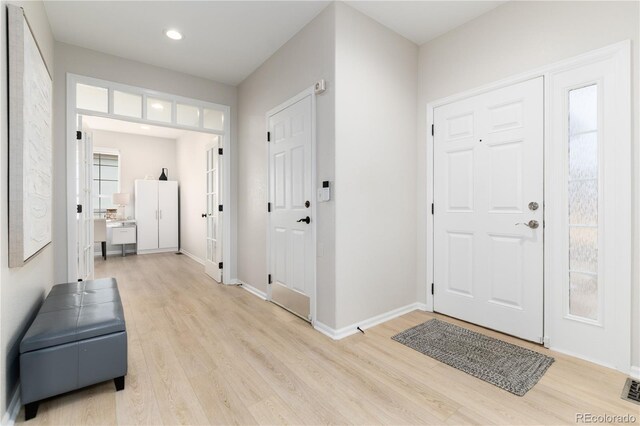 foyer entrance featuring light wood finished floors, baseboards, and recessed lighting