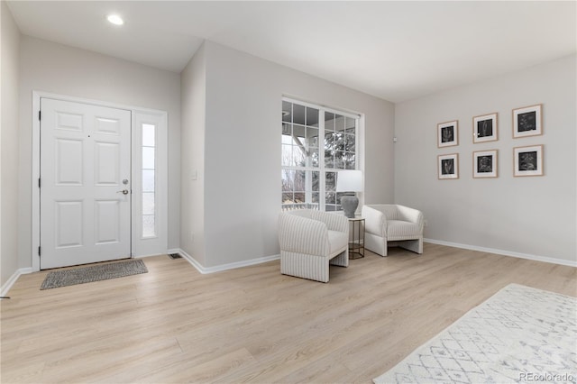 foyer with light wood-style flooring and baseboards