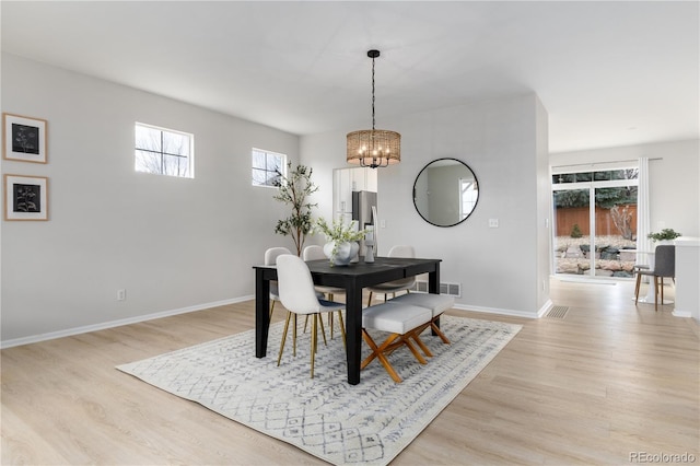 dining room with light wood-style floors, a wealth of natural light, and visible vents