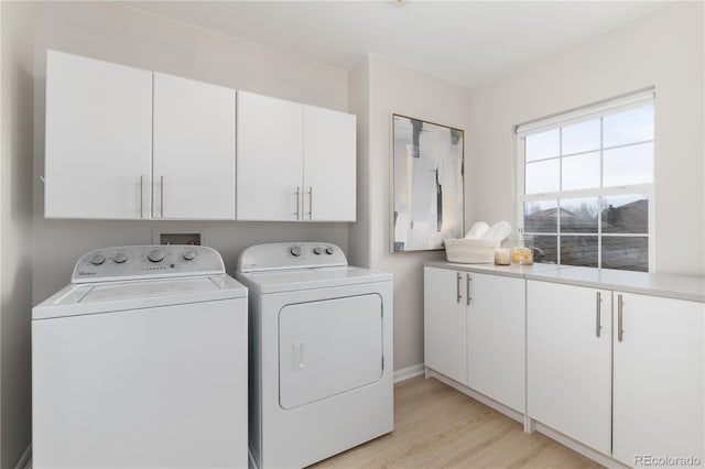 washroom featuring cabinet space, light wood finished floors, and washer and dryer