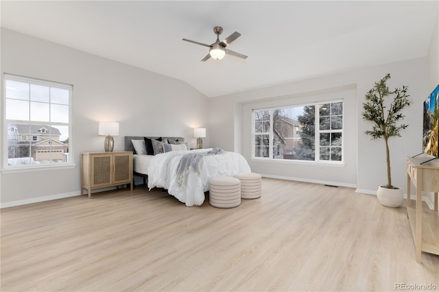 bedroom featuring light wood-style floors, baseboards, vaulted ceiling, and a ceiling fan