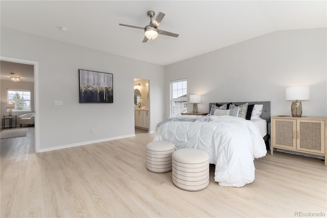 bedroom with lofted ceiling, a ceiling fan, connected bathroom, light wood-type flooring, and baseboards